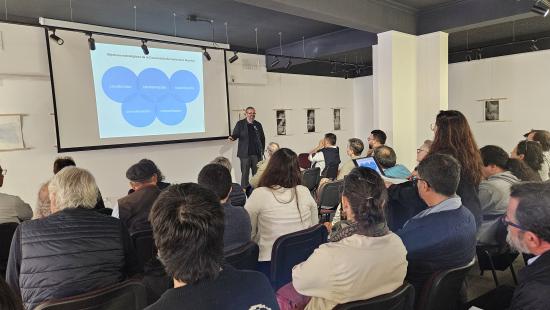 El expositor mostrando una imagen frente a un grupo de personas