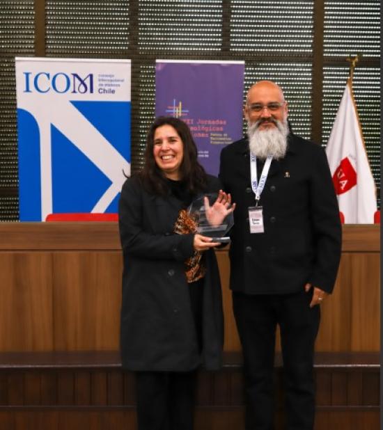 Figura femenina recibe un reconocimiento por parte de una figura masculina